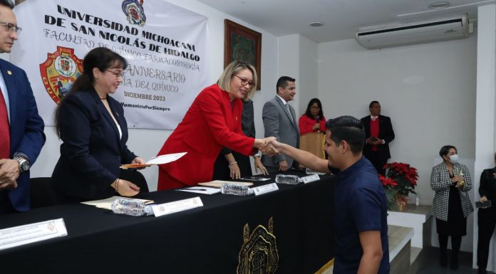 UMSNH Celebra 65 Años de Excelencia en Químico Farmacobiología La rectora Yarabí Ávila González entregando un reconocimiento a un estudiante destacado de la UMSNH por sus excepcionales logros académicos en el 65° aniversario de la Facultad de Químico Farmacobiología