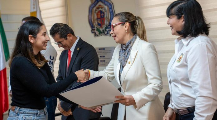 UMSNH agiliza procesos administrativos con tercera entrega masiva de títulos En un acto protocolario, la máxima autoridad de la Casa de Hidalgo hace entrega de la documentación que acredita el egreso efectivo de una joven profesionista, resaltando el compromiso de la institución con la eficiencia administrativa.