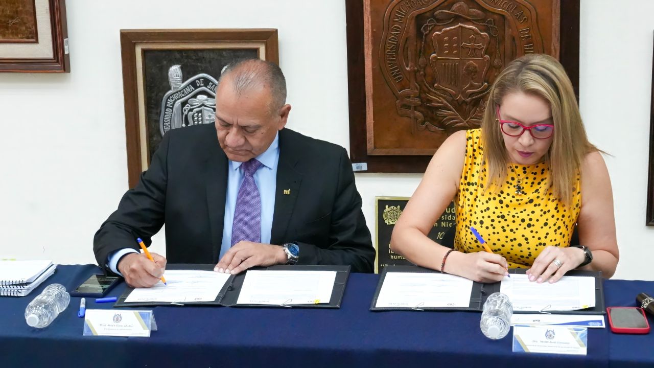 Momento exacto en que el director del IMPLAN, Rubén Flores Muñoz, y la rectora de la Universidad Michoacana, Yarabí Ávila González, estampan su rúbrica en el convenio que formaliza la colaboración entre ambas instituciones. Momento exacto en que el director del IMPLAN, Rubén Flores Muñoz, y la rectora de la Universidad Michoacana, Yarabí Ávila González, estampan su rúbrica en el convenio que formaliza la colaboración entre ambas instituciones.