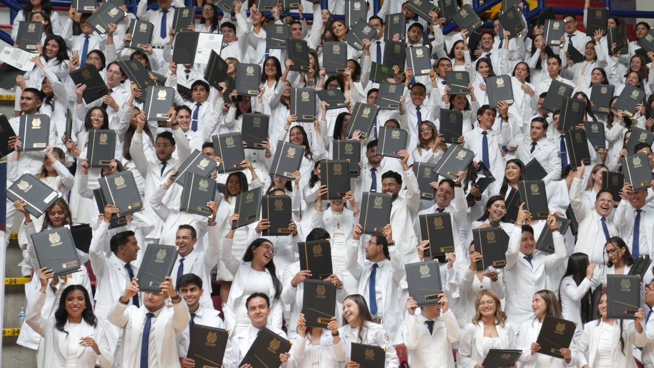 Egresadas y egresados de la Facultad de Ciencias Médicas y Biológicas de la UMSNH levantan en alto sus cartas de pasante en señal de celebración durante la ceremonia de graduación 2026. El documento acredita su calidad de pasantes de Médico Cirujano y los habilita para iniciar el internado de pregrado. Egresadas y egresados de la Facultad de Ciencias Médicas y Biológicas de la UMSNH levantan en alto sus cartas de pasante en señal de celebración durante la ceremonia de graduación 2026. El documento acredita su calidad de pasantes de Médico Cirujano y los habilita para iniciar el internado de pregrado.