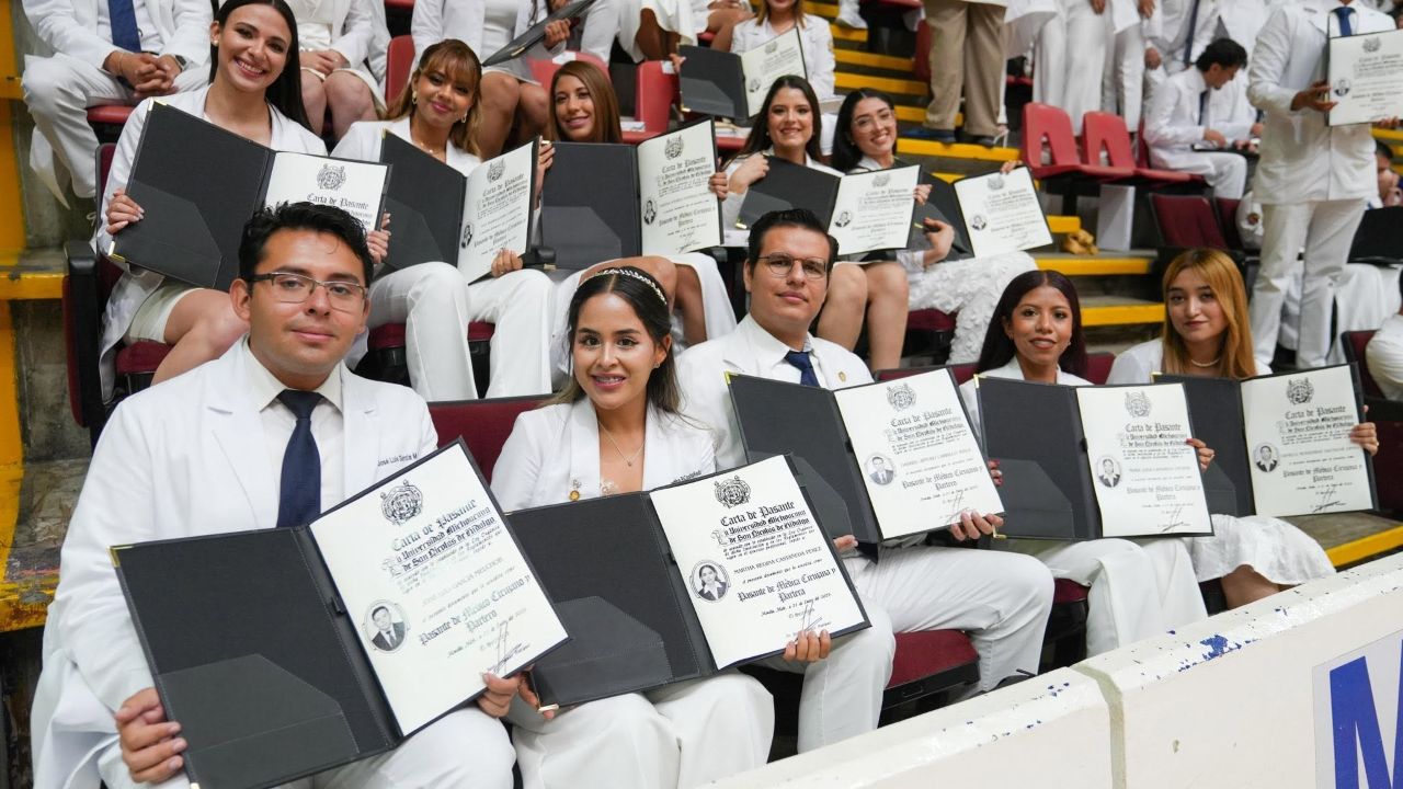 Con sus cartas de pasante de Médico Cirujano en mano, egresadas y egresados de la Facultad de Ciencias Médicas y Biológicas de la UMSNH posan para la fotografía durante la ceremonia de graduación 2026. El documento, expedido por la Universidad Michoacana de San Nicolás de Hidalgo, los acredita oficialmente como pasantes de Médico Cirujano Con sus cartas de pasante de Médico Cirujano en mano, egresadas y egresados de la Facultad de Ciencias Médicas y Biológicas de la UMSNH posan para la fotografía durante la ceremonia de graduación 2026. El documento, expedido por la Universidad Michoacana de San Nicolás de Hidalgo, los acredita oficialmente como pasantes de Médico Cirujano