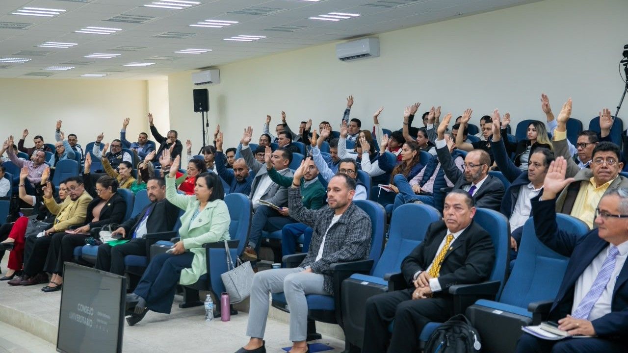 Las y los consejeros universitarios de la UMSNH emiten su voto durante la sesión en la que fue designado el doctor José Herrera Camacho como nuevo director del Instituto de Investigaciones Agropecuarias y Forestales para el periodo 2026-2030. La votación del Consejo Universitario, máximo órgano de gobierno de la institución, formalizó la designación del único candidato registrado tras la declinación de dos aspirantes. Las y los consejeros universitarios de la UMSNH emiten su voto durante la sesión en la que fue designado el doctor José Herrera Camacho como nuevo director del Instituto de Investigaciones Agropecuarias y Forestales para el periodo 2026-2030. La votación del Consejo Universitario, máximo órgano de gobierno de la institución, formalizó la designación del único candidato registrado tras la declinación de dos aspirantes.