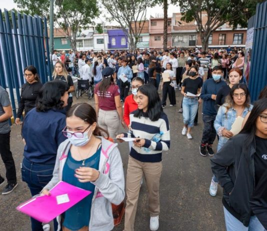 UMSNH emite recomendaciones para aspirantes que presentarán examen de admisión 2026 Decenas de aspirantes con sus documentos en mano se dirigen al acceso del recinto de evaluación durante una jornada de exámenes de admisión de la UMSNH. La imagen refleja la diversidad del universo de jóvenes que cada año busca ingresar a la Máxima Casa de Estudios de Michoacán, y subraya la importancia de llegar con anticipación suficiente para completar los protocolos de acceso antes del inicio de la prueba.