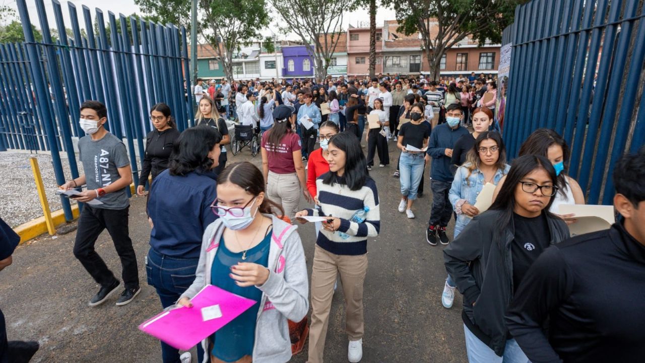 Decenas de aspirantes con sus documentos en mano se dirigen al acceso del recinto de evaluación durante una jornada de exámenes de admisión de la UMSNH. La imagen refleja la diversidad del universo de jóvenes que cada año busca ingresar a la Máxima Casa de Estudios de Michoacán, y subraya la importancia de llegar con anticipación suficiente para completar los protocolos de acceso antes del inicio de la prueba. Decenas de aspirantes con sus documentos en mano se dirigen al acceso del recinto de evaluación durante una jornada de exámenes de admisión de la UMSNH. La imagen refleja la diversidad del universo de jóvenes que cada año busca ingresar a la Máxima Casa de Estudios de Michoacán, y subraya la importancia de llegar con anticipación suficiente para completar los protocolos de acceso antes del inicio de la prueba.