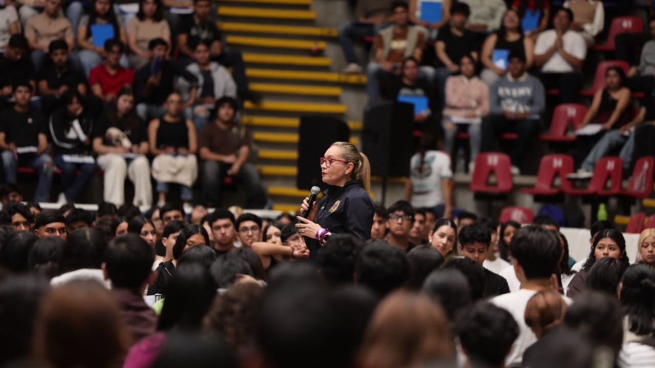 La rectora Yarabí Ávila González se dirige al micrófono ante miles de aspirantes congregados en el auditorio nicolaita, instándolos a conducirse con integridad y esfuerzo escolar. La rectora Yarabí Ávila González se dirige al micrófono ante miles de aspirantes congregados en el auditorio nicolaita, instándolos a conducirse con integridad y esfuerzo escolar.