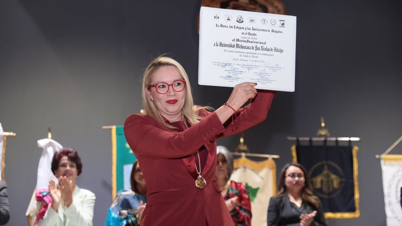 La rectora Yarabí Ávila González sostiene en alto el pergamino de la Venera al Mérito Institucional en el Fortalecimiento del Estado de Derecho otorgado a la UMSNH. La rectora Yarabí Ávila González sostiene en alto el pergamino de la Venera al Mérito Institucional en el Fortalecimiento del Estado de Derecho otorgado a la UMSNH.