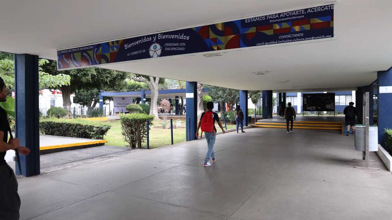 Vista del pasillo de acceso principal a las instalaciones de la Universidad Michoacana de San Nicolás de Hidalgo (UMSNH), donde lona institucional da la bienvenida a estudiantes y personas con discapacidad al inicio de actividades académicas. Vista del pasillo de acceso principal a las instalaciones de la Universidad Michoacana de San Nicolás de Hidalgo (UMSNH), donde lona institucional da la bienvenida a estudiantes y personas con discapacidad al inicio de actividades académicas.