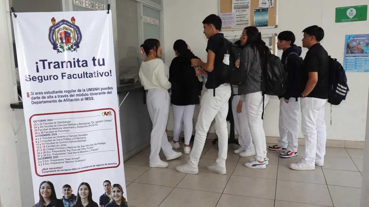 Estudiantes de la UMSNH se alinean frente a un módulo de atención para iniciar el trámite de su Seguro Facultativo del IMSS. Un banner oficial promueve la campaña de afiliación para diversas dependencias académicas. Estudiantes de la UMSNH se alinean frente a un módulo de atención para iniciar el trámite de su Seguro Facultativo del IMSS. Un banner oficial promueve la campaña de afiliación para diversas dependencias académicas.