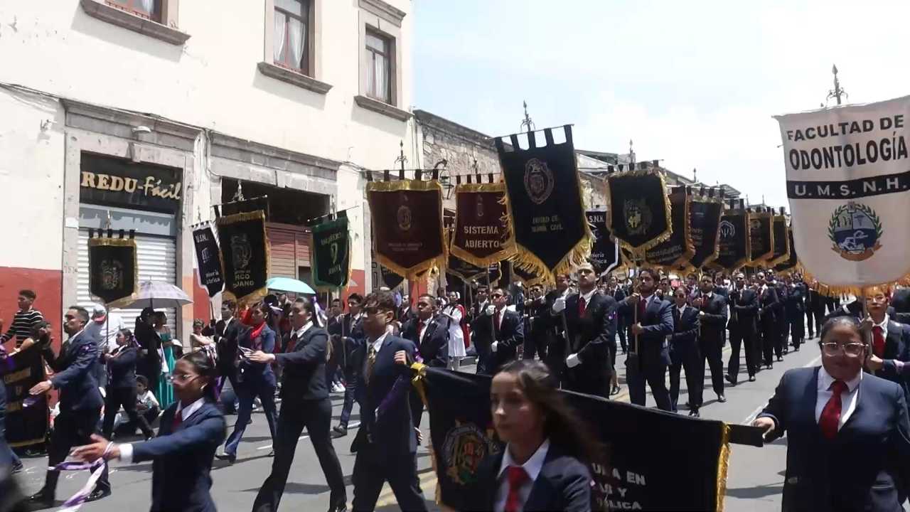 Estandartes históricos de facultades y dependencias de la UMSNH abren paso al contingente universitario durante el desfile patrio en Morelia. Estandartes históricos de facultades y dependencias de la UMSNH abren paso al contingente universitario durante el desfile patrio en Morelia.