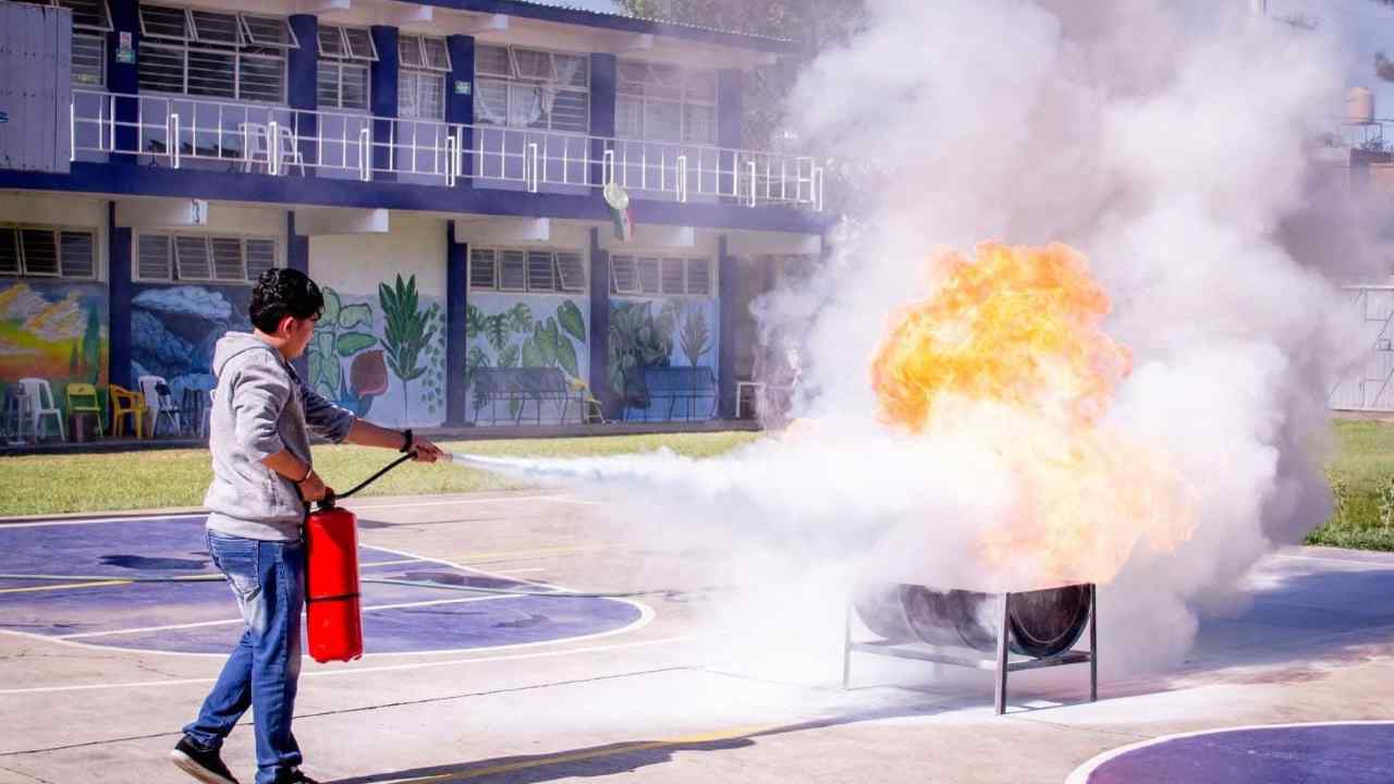 Estudiante practica el uso de extintor durante taller de combate de incendios realizado en instalaciones de la UMSNH en el marco de la Jornada Nacional de Protección Civil. Estudiante practica el uso de extintor durante taller de combate de incendios realizado en instalaciones de la UMSNH en el marco de la Jornada Nacional de Protección Civil.